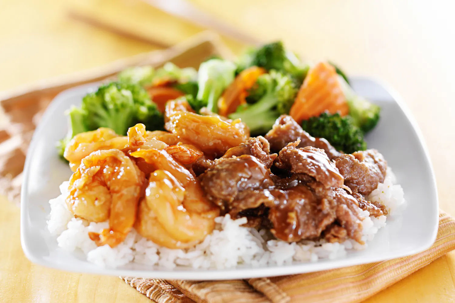 Combination plate of teriyaki shrimp and beef with steamed rice and mixed veggies