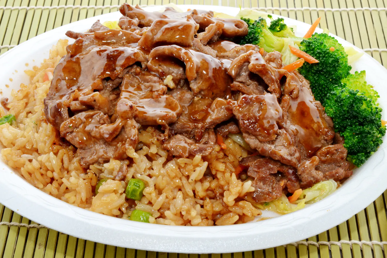 Beef teriyaki plate over fried rice with broccoli and mixed vegetables