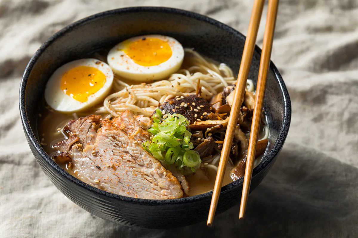 Savory ramen bowl with pork slices, soft‑boiled eggs, mushrooms and green onions